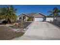 Tan house with a two-car garage and landscaped front yard at 2775 Sw 158Th St, Ocala, FL 34473