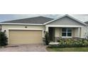 One-story home with a beige exterior, stone accents, and a two-car garage at 29567 Caspian St, Leesburg, FL 34748