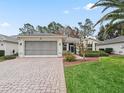 House exterior featuring a paved driveway and well-maintained lawn at 353 Ranchwood Dr, Leesburg, FL 34748