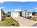 Gray house with a two-car garage and driveway, plus a fire hydrant at 3575 Grouby Rd, The Villages, FL 32163