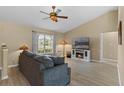 Living room with sectional sofa, electric fireplace, and vaulted ceiling at 438 Woodview Dr, Tavares, FL 32778