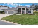 House with three-car garage, screened porch, and lush green lawn at 4928 Kelso St, Leesburg, FL 34748