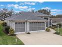 One-story house featuring a three-car garage and landscaped front yard at 4928 Kelso St, Leesburg, FL 34748