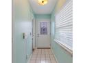 Light teal entryway with white door, tile floor and window with blinds at 500 Southern Charm Dr, Orlando, FL 32807