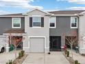 Two-story townhouse featuring a gray painted facade, a one-car garage, and minimal landscaping at 5278 Dragonfly Dr, Wildwood, FL 34785