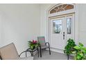 Inviting front porch with decorative door and potted plants at 5318 Fantasy Way, Leesburg, FL 34748