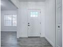 Interior view of entryway with white door and gray flooring at 808 E Orange St, Apopka, FL 32703