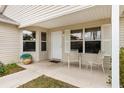 Covered porch with two chairs and brick flooring at 860 Evelynton Loop, The Villages, FL 32162