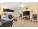 Living room with gray couch and laminate wood floor at 860 Evelynton Loop, The Villages, FL 32162