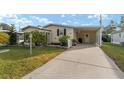 Well-maintained manufactured home with carport and landscaping at 1007 Dustin Dr, The Villages, FL 32159