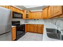 Well-equipped kitchen featuring wood cabinets and stainless steel appliances at 102 Camino Real Blvd # 102, Howey In The Hills, FL 34737