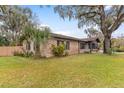 A charming one-story brick home with blue shutters and lush landscaping at 1208 Gibson St, Leesburg, FL 34748