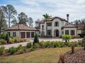 Impressive two-story house with a three-car garage and lush landscaping at 15118 Pendio Dr, Bella Collina, FL 34756