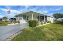 Single-wide home with covered porch and lush landscaping at 16 Captains Pt, Fruitland Park, FL 34731