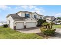 Charming two-story home boasts a three-car garage, manicured lawn, mature landscaping, and neutral paint at 16428 Good Hearth Blvd, Clermont, FL 34711