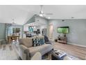 Open concept living room and kitchen with light flooring, neutral decor, and a large TV at 1660 1St St, Clermont, FL 34711