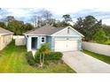 Well maintained single story home with tidy landscaping, an attached two-car garage, and a paved driveway at 2295 Delhi Pl, Sanford, FL 32771
