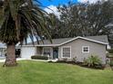Newly renovated home with a landscaped yard and palm trees at 25141 Clifford Hl, Leesburg, FL 34748