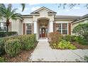 Attractive front entry with columns and lush landscaping at 2747 Spicebush Loop, Apopka, FL 32712