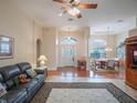 Spacious living room with hardwood floors, a ceiling fan, and a comfortable leather couch at 27504 Stoney Brook Dr, Leesburg, FL 34748
