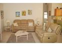 Living room with neutral colored couches and coffee table at 3243 Mansfield St, The Villages, FL 32162