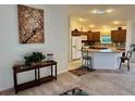 Open-concept living room flowing into a kitchen with a breakfast bar and modern appliances at 3554 Oracle Ct, The Villages, FL 32163