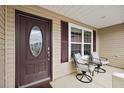 Cozy front porch features neutral furnishings and decorative glass front door at 507 Delfin Rd, The Villages, FL 32163