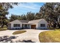 Farmhouse exterior with attached garage and circular driveway at 871 Cr 548, Bushnell, FL 33513