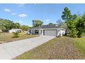 Inviting one-story home with a spacious driveway and low maintenance landscaping in the front yard at 9139 Se 155Th Pl, Summerfield, FL 34491