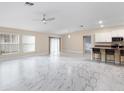Spacious living room with marble floors, a ceiling fan, and access to kitchen area at 9334 Sw 57Th Ave, Ocala, FL 34476