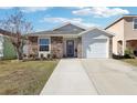 One story home with stone accents, and a two-car garage at 12306 Ne 48Th Way, Oxford, FL 34484