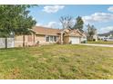 Landscaped yard with a tan house and two-car garage at 1381 Winterville St, Deltona, FL 32725