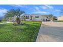 Landscaped lawn with palm tree and single-wide manufactured home at 1706 Pebble Beach Ln, Lady Lake, FL 32159