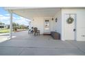 Covered patio with seating and storage; view of the neighborhood at 1706 Pebble Beach Ln, Lady Lake, FL 32159