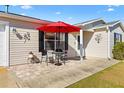 Cozy patio area with red umbrella and outdoor seating at 1842 Captiva Ct, The Villages, FL 32162