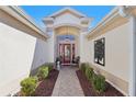 Inviting entryway with red door and decorative wall art at 2134 Zaragoza Pl, Lady Lake, FL 32159