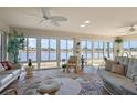 Bright sunroom with lake view, wicker furniture, and tile floor at 2134 Zaragoza Pl, The Villages, FL 32159