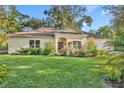 Tan house with brown roof, landscaping, and a two-car garage at 214 Forest Park Ln, Lady Lake, FL 32159