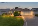 Attractive single-story home with well-manicured lawn at dusk at 2240 Avon Loop, The Villages, FL 32162