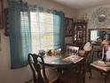 Small dining area with round table and teal curtains at 225 N West St, Bushnell, FL 33513