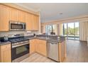 Kitchen with light wood cabinets, stainless steel appliances, and a view of a lake at 2298 Caledonian St, Clermont, FL 34711