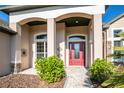 Inviting entryway with a red door and brick walkway at 2441 Bar Harbor Bay, Mount Dora, FL 32757