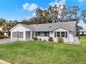 Attractive single-story home boasting a lush green lawn, a screened garage, and inviting curb appeal at 25941 Newcombe Cir, Leesburg, FL 34748