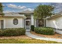 Front entrance with walkway, landscaping, and white exterior at 26908 Honeymoon Ave, Leesburg, FL 34748