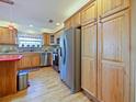 Kitchen with wood cabinets, stainless steel appliances, and red island at 2762 Morven Park Way, The Villages, FL 32162