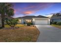 House exterior at dusk showcasing a single story home with landscaping and driveway at 3488 Sterling St, The Villages, FL 32162