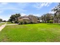 Large green backyard with a view of the house at 4077 Greystone Dr, Clermont, FL 34711