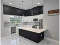 Modern kitchen with white cabinets, island, and marble countertops at 42025 Royal Trails Rd, Eustis, FL 32736