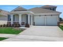Inviting home boasting a spacious two-car garage, a well-maintained lawn, and a welcoming covered entrance at 5119 Firebush Dr, Apopka, FL 32712