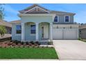 Charming two-story home features a two-car garage and landscaped front yard, creating appealing curb appeal at 5155 Firebush Dr, Apopka, FL 32712